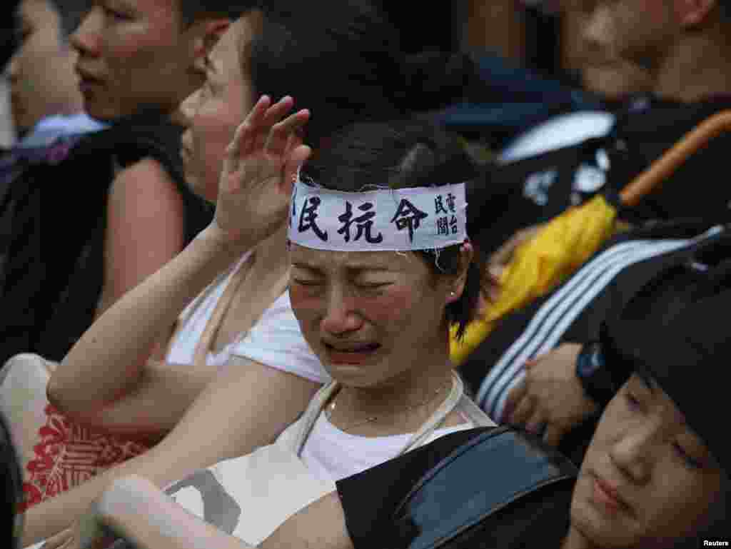 A protester wearing a headband which reads "civil disobedience" cries before being dragged away by police after staying overnight at Hong Kong's financial district July 2, 2014.
