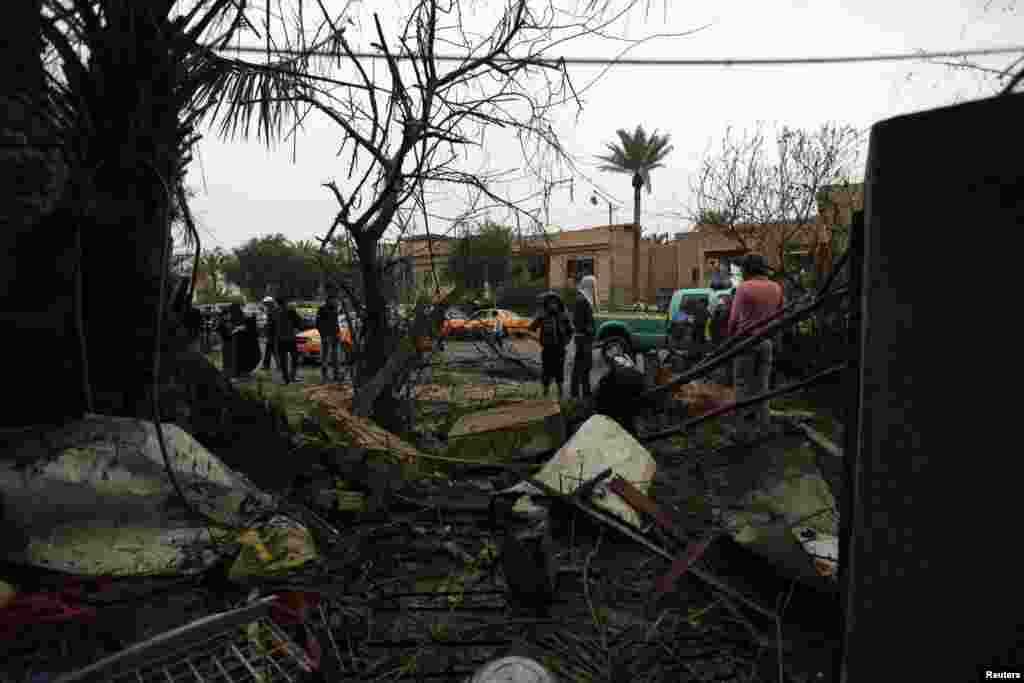 People gather at the site of a car bomb attack in Baghdad, Feb. 3, 2014.