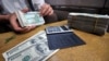 Un bureau de change illégal échangeant des billets de banque en kyats du Myanmar contre des dollars américains à Yangon, le 3 septembre 2011, au Myanmar, qui a faire appel au FMI pour de l'aide. AFP PHOTO / Soe Than WIN (Photo par Soe Than WIN / AFP)