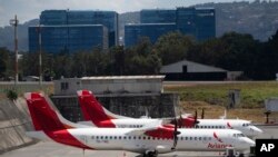 Aircraft from the Avianca airline sit parked at La Aurora airport in Guatemala City, Tuesday, March 17, 2020. 