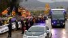 FILE - Demonstrators wave esteladas or independence flags as a bus of the Spain's Civil Guard carrying the nine Catalonian politicians and activists, leaves the Brians II prison, in Barcelona, Spain, Feb.1, 2019.