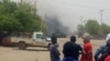 Quelques personnes regardent au loin le lieu d’une attaque-kamikaze dans la région de Gao, dans le centre-nord du Mali, 1er juillet 2018. (VOA/ Sidi Elhabib Maiga)