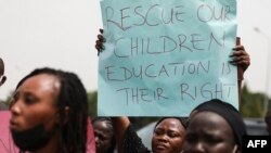 Wazazi na ndugu wa wanafunzi wa chuo cha serikali cha Misitu wakiwa wamebeba mabango wakati wa maandamano mjini Abuja kudai kuachiwa kwa wanafmilia wao waliotekwa (Picha na Kola Sulaimon / AFP) Mei 4, 2021.