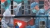 Seorang pekerja menambahkan sentuhan akhir pada mural raksasa untuk para pekerja garis depan dalam pandemi virus corona COVID-19 di luar rumah sakit di Kuala Lumpur, Malaysia, pada Kamis, 21 Januari 2021. (Foto: AP)