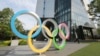 Seorang pria berjalan melewati cincin Olimpiade di Tokyo, Senin, 7 Juni 2021. (Foto: AP/Koji Sasahara)