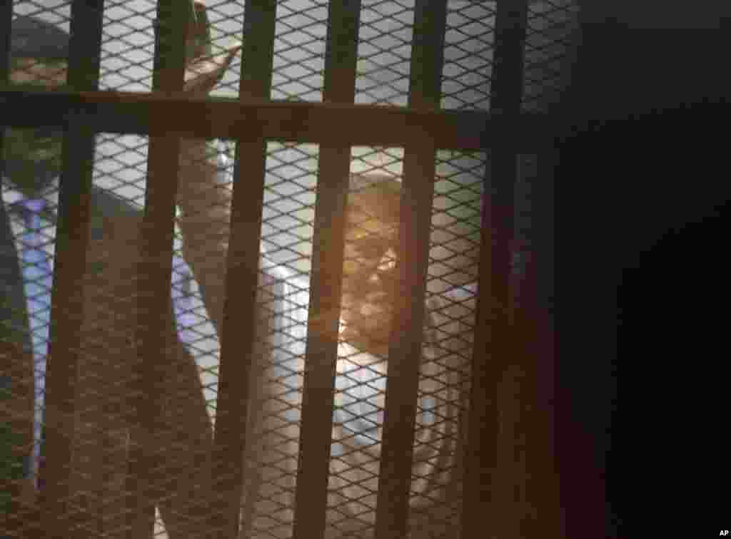 Egypt's ousted Islamist president Mohamed Morsi sits in a soundproof glass cage inside a makeshift courtroom at Egypt’s national police academy in Cairo, April 21, 2015.