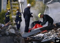 FILE - Emergency workers search through rubble at the site of the CTV building in Christchurch, New Zealand, Feb. 24, 2011, after the city was hit by an earthquake Tuesday.