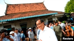 Sam Rainsy, president of the Cambodia National Rescue Party (CNRP), visits a polling station during the general elections at a pagoda in Phnom Penh July 28, 2013.