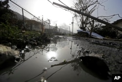 FILE - Downed power lines and debris are seen in the aftermath of Hurricane Maria in Yabucoa, Puerto Rico, Sept. 26, 2017.