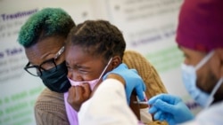 Markeata West holds her daughter, Justice, 6, as she receives the Pfizer COVID-19 vaccine for children 5-11 from Dr. Eugenio Fernandez at Asthenis Pharmacy in Providence, RI, Nov. 5, 2021.