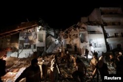 Civilians and civil defense members look for survivors at a site damaged after suspected Russian airstrikes on the Syrian rebel-held city of Idlib, Syria, late May 30, 2016.