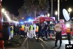 FILE - Police officers, firefighters and rescue workers are seen at the site of an attack on July 15, 2016, after a truck drove into a crowd watching a fireworks display in the French Riviera town of Nice.
