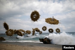 FILE - Amphibious assault vehicles of the South Korean Marine Corps fire smoke bombs as they come ashore during a U.S.-South Korea joint landing operation drill as a part of the two countries' annual military training called Foal Eagle, in Pohang, South Korea.