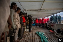 Migrants gather on the deck of the Spanish NGO Proactiva Open Arms rescue vessel after being rescued in the central Mediterranean Sea, Dec. 21, 2018, before disembarking in the port of Crinavis in Spain, Dec. 28, 2018.