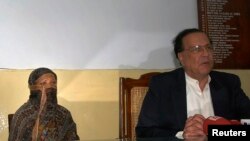 سلمان تاتیر ذرائع ابلاغ سے بات کر رہے ہیں اور عقب میں آسیہ بی بی بیٹھی ہیں۔(2010ء کی ایک تصویر)