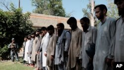 Islamic State fighters arrested by Afghan security personal stand outside the Afghan police headquarters in Jalalabad, east of Kabul, Afghanistan, May 9, 2016.