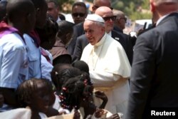 FILE - Pope Francis greets internally displaced people sheltering on the grounds of the Saint Sauveur church, during his visit in the capital Bangui, Central African Republic, Nov. 29, 2015.
