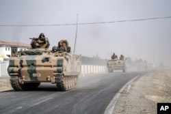 FILE - Turkish army tanks and armored personnel carriers move toward the Syrian border, in Karkamis, Turkey, Aug. 25, 2016.