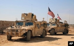 FILE - U.S. forces take up positions on the outskirts of the Syrian town of Manbij, March 7, 2017.