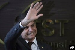 Brazil's President-elect Jair Bolsonaro waves to supporters as he arrives to the Supreme Labor Court in Brasilia, Brazil, Nov. 13, 2018. Bolsonaro, a far-right former army captain, assumes office Jan. 1.