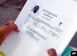 In this picture taken June 9, 2106, Hiweet Berhe Tesfamarian Kidane holds photocopies of documents she told the Associated Press belong to her brother, Medhane Tesfamariam Berhe, during an interview in Oslo.
