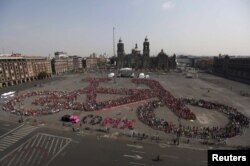 FILE - Cyclists gather to form a shape of a bicycle with the aim of promoting cycling as a mode of transport and to commemorate Bicycle Day, which is celebrated April 19 annually, at Zocalo square in Mexico City, Mexico, April 10, 2016.