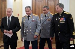 From the left: Russian President Vladimir Putin, Defense Minister Sergei Shoigu, Head of the General Staff of the Armed Forces of Russia and First Deputy Defense Minister Valery Gerasimov, and Deputy GRU chief, Vice Adm. Igor Kostyukov walk to attend a meeting marking the centenary of Russia's military intelligence, GRU in Moscow, Russia, Nov. 2, 2018.