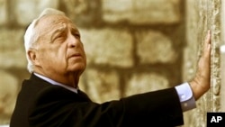 FILE - Ariel Sharon, Israel's then-Prime Minister-elect, touches Judaism's holiest site, the Western Wall, Jerusalem, Feb. 7, 2001.