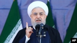 Iran's President Hassan Rouhani speaks at a military parade marking the 38th anniversary of Iraq's 1980 invasion of Iran, in front of the shrine of the late revolutionary founder, Ayatollah Khomeini, outside Tehran, Iran, Sept. 22, 2018.
