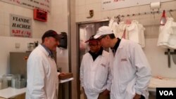 Philippe Zribi (L) is seen with employees at Boucherie de l'Argonne, in Paris, Feb. 3, 2016. (L. Bryant/VOA)