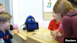 FILE - Students use a mathematics teaching robot, OVObot, during their lesson at the school in Tampere, Finland, March 27, 2017.