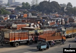 FILE - Trucks are seen parked in an open lot near a national highway on the outskirts of Ahmedabad, India, Dec. 2, 2015.