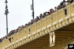People stand on the Margaret Bridge to watch the recovery operations for a capsized boat in Budapest, Hungary, May 30, 2019.