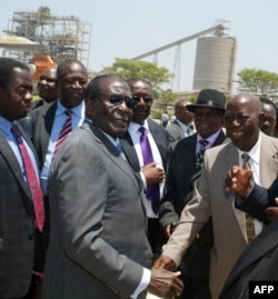FILE - Zimbabwe's President Robert Mugabe (C-L) greets local chiefs at Zimplats mine, outside Harare.