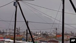 FILE - A view of electrical poles and wires at a suburb, with Table Mountain in backdrop, near the city of Cape Town, South Africa, Sept. 27, 2013.
