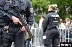 FILE - Police patrol near the Brandenburg Gate in Berlin, Germany, May 24, 2017.