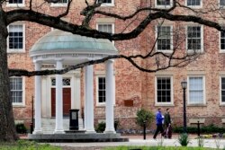 FILE - People remove belongings on campus at the University of North Carolina in Chapel Hill, N.C., March 18, 2020.