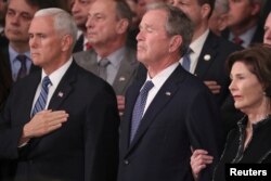 (L-R) U.S. Vice President Mike Pence, former President George W. Bush and former first lady Laura Bush watch as the casket of former President George H.W. Bush arrives to lie in state in the U.S. Capitol Rotunda in Washington, U.S., Dec. 3, 2018.