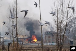 FILE - Flames and smoke billows from a residential building where militants are suspected to have taken refuge during a gun battle in Pulwama, south of Srinagar, Indian controlled Kashmir, Monday, Feb. 18, 2019.