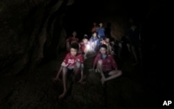 This July 2, 2018, photo released by Tham Luang Rescue Operation Center, shows the boys and their soccer coach as they were found in a partially flooded cave, in Mae Sai, Chiang Rai, Thailand