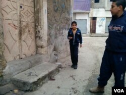Families point out blood spatters left from a child who was killed by an Islamic State mortar on Thursday in Mosul, Iraq, Jan. 27, 2017. (H. Murdock/VOA)
