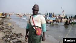 Doudou Kote, the captain of a Senegalese fishing vessel, stands on the beach at Joal-Fadiouth, a hub of the country's fishing industry, April 10, 2018.