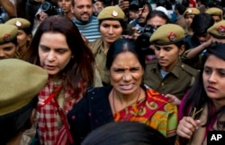 The mother (c) of the victim of the fatal 2012 gang rape that shook India arrives to lend her support at a protest in New Delhi, India, Dec. 21, 2015.