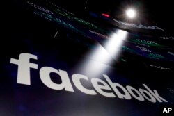 FILE - Facebook appears on screens at the Nasdaq MarketSite in New York's Times Square.
