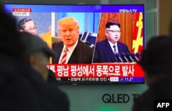People watch a television news screen showing pictures of U.S. President Donald Trump and North Korean leader Kim Jong Un, at a railway station in Seoul, South Korea, Nov. 29, 2017.