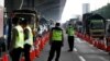 Polisi mengenakan masker memeriksa kendaraan yang lewat, menyusul larangan mudik yang ditetapkan pemerintah untuk mencegah penyebaran wabah virus COVID-19 di Bekasi, pinggiran Jakarta, 24 April 2020. (Foto: dok).