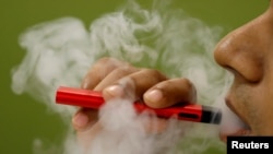 Seorang pria merokok dengan rokok elektrik, 19 September 2019.