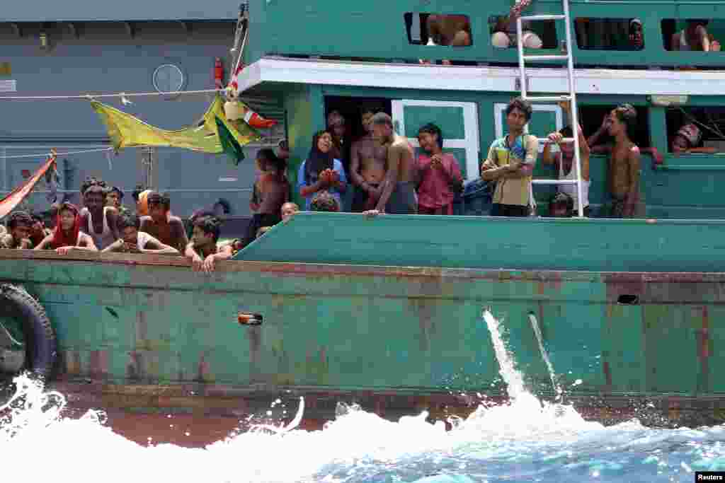 Beberapa migran putus asa setelah angkatan laut Thailand menghalau kapal mereka dari negara itu, di perairan dekat pulau Koh Lipe (16/5). (Reuters/Aubrey Belford)