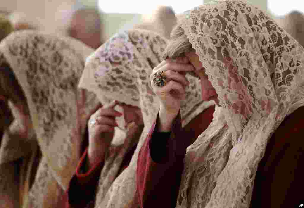 Para perempuan dari gereja Orthodox Suriah,&nbsp;Saint Afram, melakukan doa pada pagi hari di hari Natal di kota Amman, Yordania. 