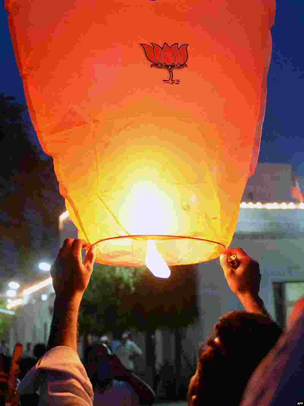 Seorang India pendukung Partai Bharatiya Janata (BJP) mempersiapkan peluncuran sebuah lentera udara yang dihiasi dengan lotus, simbol Partai BJP, di markas partai itu di New Delhi. 